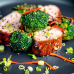 Char siu pork tenderloin, or Chinese BBQ pork served with broccoli stir fry and chilli featuring a title overlay.