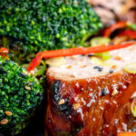 Close up char siu pork tenderloin, or Chinese BBQ pork served with broccoli stir fry.