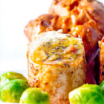 Close up sage and onion stuffed chicken ballotine served with gravy and sprouts.