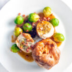 Overhead sage and onion stuffed chicken ballotine served with gravy, Yorkshire pudding & sprouts.