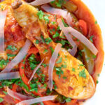 Close up overhead chicken Basque with peppers and tomatoes.
