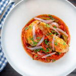 Overhead chicken Basque with peppers and tomatoes.