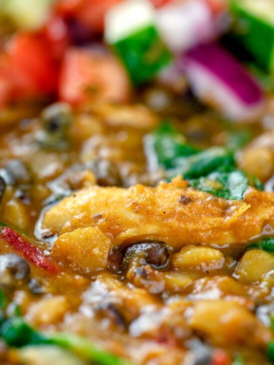 Close up chicken dhansak lentil curry with kachumber salad.