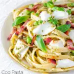 Cod pasta with pesto, peas and bacon served on a white plate featuring a title overlay.