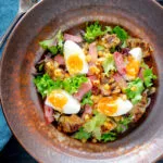 Overhead gammon salad with seared pineapple, boiled eggs and potatoes.