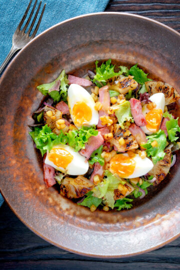 Overhead gammon salad with seared pineapple, boiled eggs and potatoes.