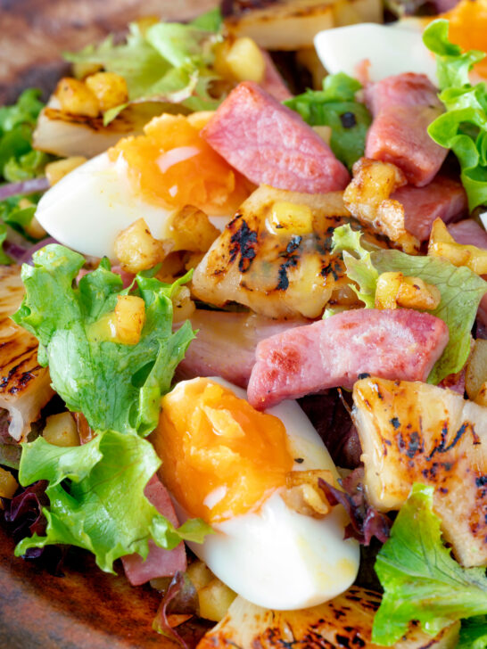 Close up gammon salad with seared pineapple, boiled eggs and potatoes.