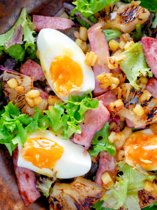 Close up overhead gammon salad with seared pineapple, boiled eggs and potatoes.