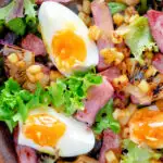 Close up overhead gammon salad with seared pineapple, boiled eggs and potatoes featuring a title overlay.