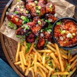 Overhead Korean influenced chicken wings served with fries and kimchi.