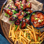 Overhead Korean influenced chicken wings served with fries and kimchi featuring a title overlay.