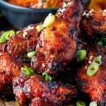 Close up Korean influenced chicken wings served with kimchi.