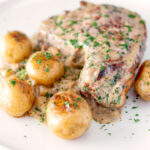 Thick cut Normandy pork chops in a creamy cider sauce with potatoes.