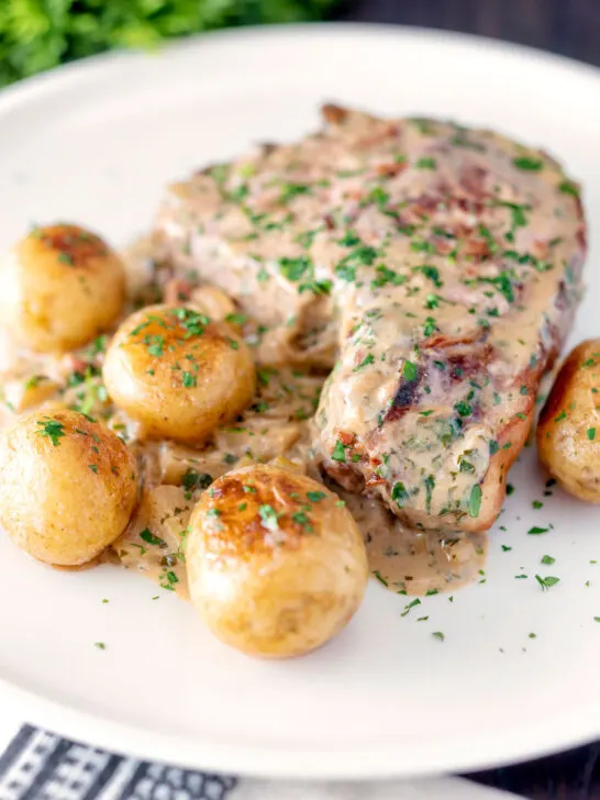 Thick cut Normandy pork chops in a creamy cider sauce with potatoes.