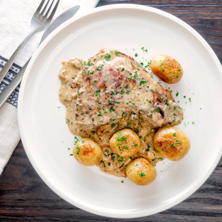 Thick cut Normandy pork chops in a creamy cider and brandy sauce with potatoes.