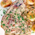 Overhead thick cut Normandy pork chops in a creamy cider sauce with potatoes featuring a title overlay.