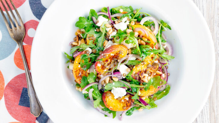 Peach and feta cheese salad with puy lentils, rocket and pine nuts.