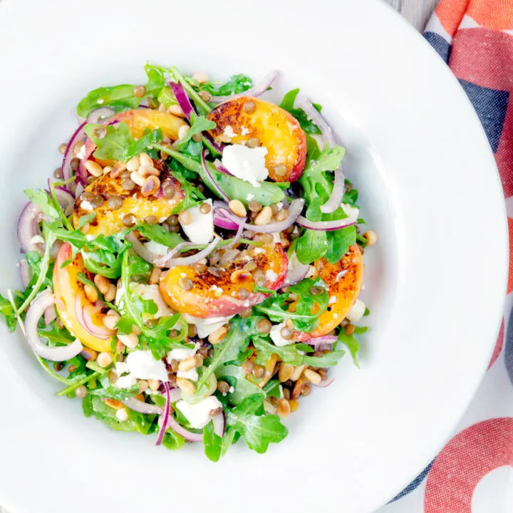 Peach and feta cheese salad with puy lentils, rocket and pine nuts.