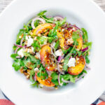 Overhead peach and feta cheese salad with puy lentils and rocket or arugula.
