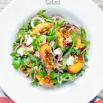 Overhead peach and feta cheese salad with puy lentils and rocket or arugula featuring a title overlay.