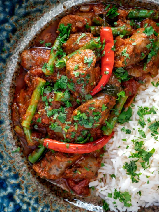 Close up overhead Indian inspired beef sausage curry served with rice.