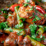 Close up Indian inspired beef sausage curry featuring a title overlay.