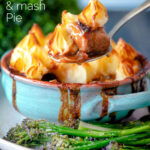 Spoon taking a serving of sausage and mash pie with roasted tenderstem broccoli featuring a title overlay.
