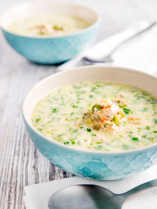 Slow cooker salmon chowder served in blue bowls.