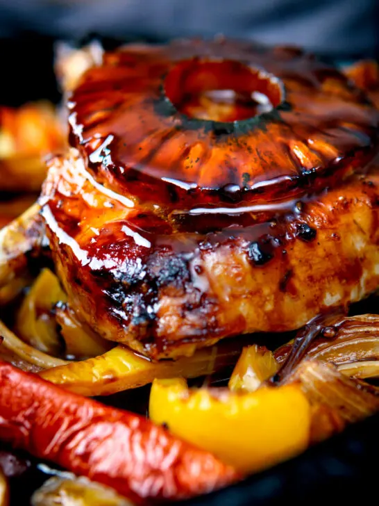 Close up sweet and sour pork chops with pineapple rings and peppers.