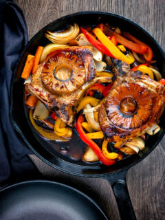 Overhead skillet sweet and sour pork chops with pineapple and peppers.