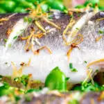 Close up baked whole sea bass featuring a title overlay.