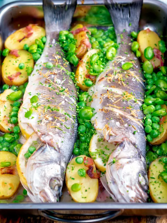 Baked or roasted sea bass with new potatoes, peas, broad beans and bacon.