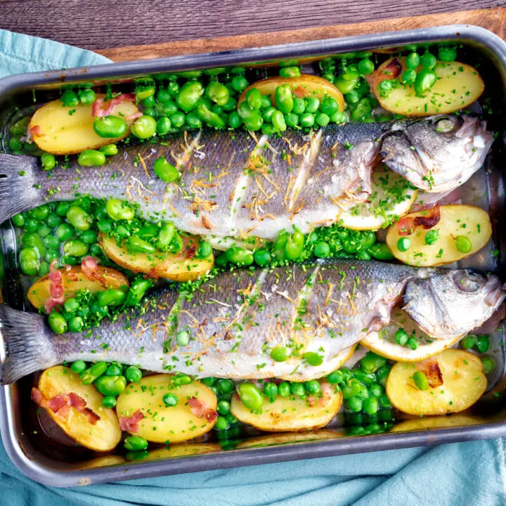 Whole baked or roasted sea bass with new potatoes, peas, broad beans and bacon.