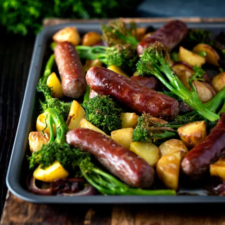 Beef sausage and potato tray bake with onions and tenderstem broccoli.