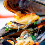 Close up beer steamed mussels with shallot, chilli and garlic.