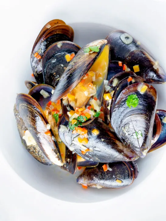 Overhead beer steamed mussels with shallot, chilli and garlic.