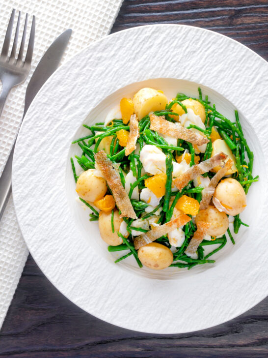 Overhead cod fish salad with asparagus, samphire, new potatoes and orange.