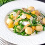 Cod fish salad with asparagus, samphire, new potatoes, crispy fish skin and orange featuring a title overlay.