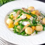 Cod fish salad with asparagus, samphire, new potatoes, crispy fish skin and orange featuring a title overlay.