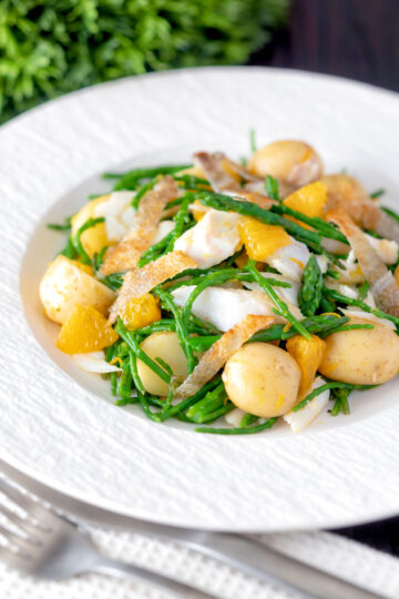 Cod fish salad with asparagus, samphire, new potatoes, crispy fish skin and orange featuring a title overlay.