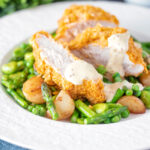 Oven baked cornflake coated chicken breast served with mustard sauce and veggies.