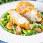 Oven baked cornflake coated chicken breast served with mustard sauce and veggies.