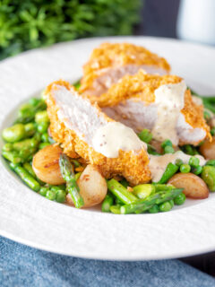 Oven baked cornflake coated chicken breast served with mustard sauce and veggies.