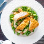 Overhead oven baked cornflake coated chicken breast served with mustard sauce and veggies.