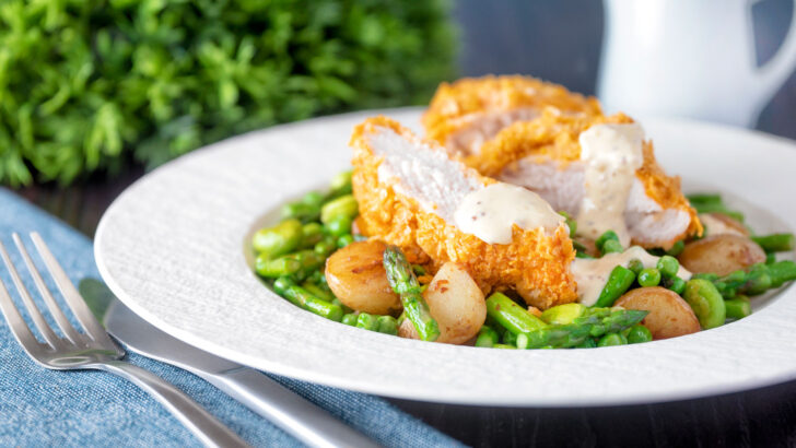 Oven baked cornflake coated chicken breast served with mustard sauce and sautéed veggies.