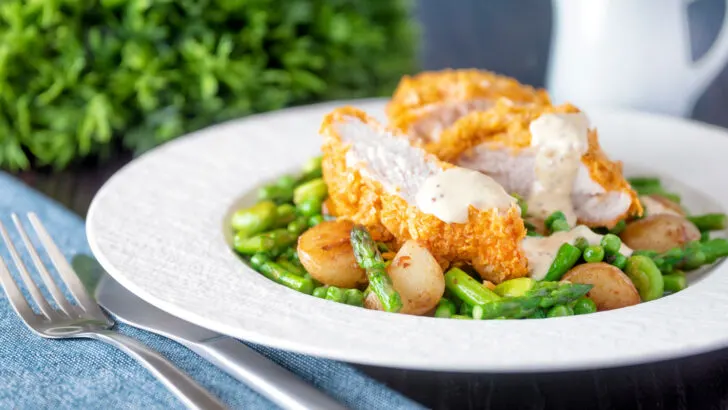 Oven baked cornflake coated chicken breast served with mustard sauce and sautéed veggies.