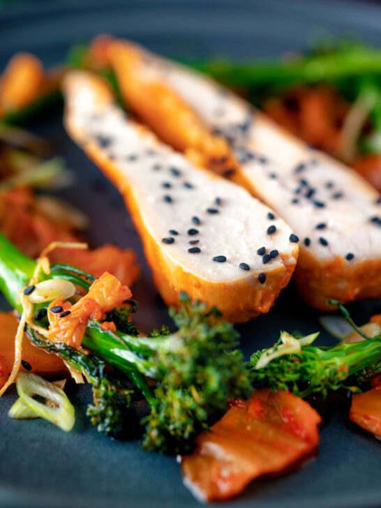 Close up steamed Korean gochujang chicken breast with broccoli and kimchi.