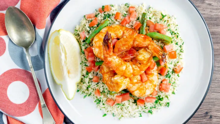 Moroccan influenced garlic harissa prawns served with herby couscous, tomatoes and green beans.
