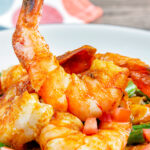 Close up Moroccan influenced garlic harissa prawns served with couscous.