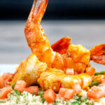 Moroccan influenced garlic harissa prawns served with couscous.